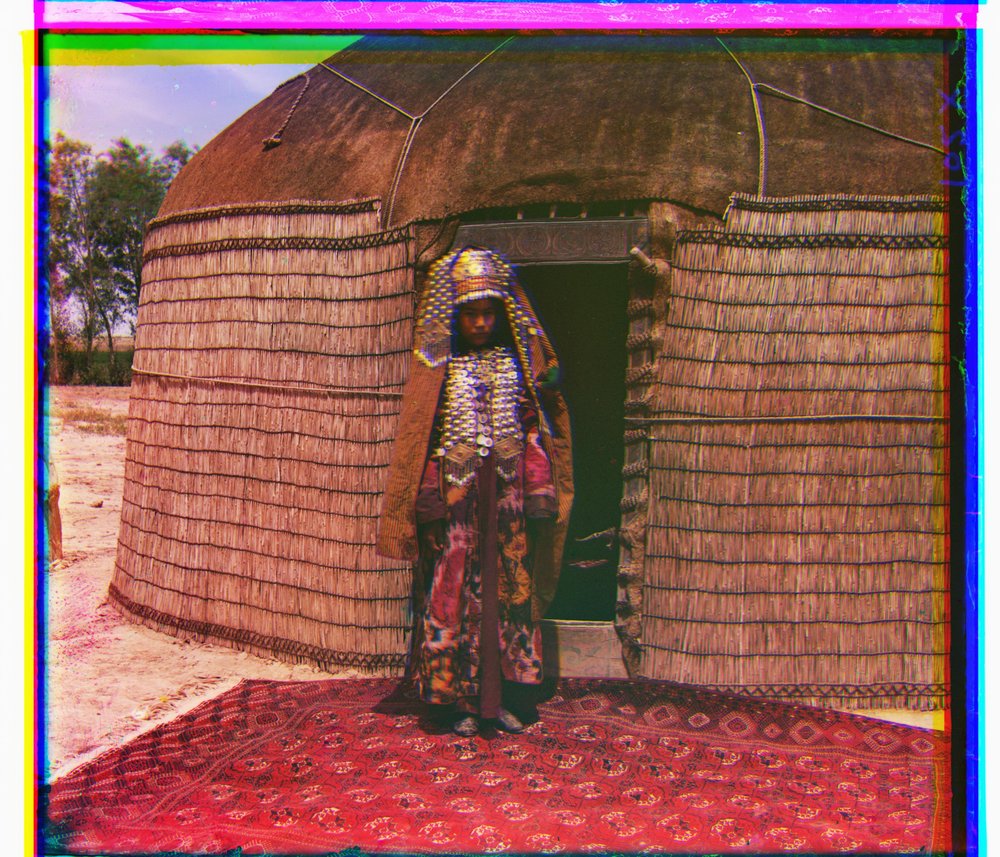 Woman in traditional dress in front of a yurt